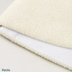 Macro texture shot of the soft, fluffy white fleece top surface and the dotted anti-slip bottom fabric of the mat.